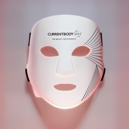 White face mask with 'CURRENTBODY' branding on a gradient pink and purple background