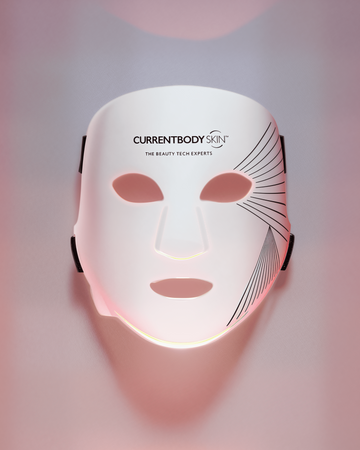White face mask with 'CURRENTBODY' branding on a gradient pink and purple background