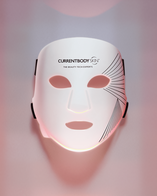 White face mask with 'CURRENTBODY' branding on a gradient pink and purple background