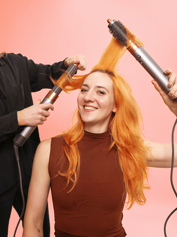 woman styling her hair with dyson airwrap